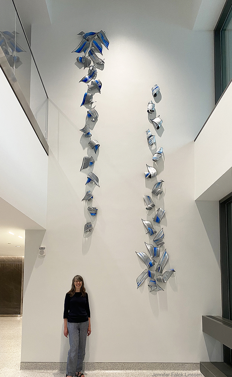 Jennifer Falck Linssen with Affinity wall sculpture in the main lobby of Sentry Insurance, Stevens Point, WI